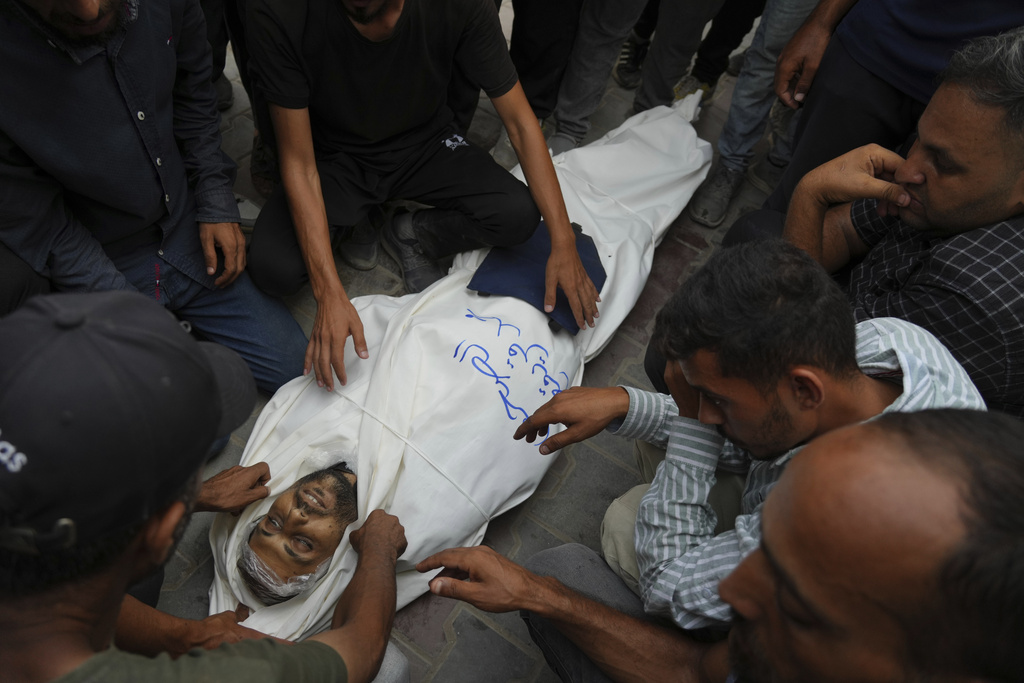 Colleagues and friends mourn over the body Al Jazeera correspondent Mohamed Qureiqa who was killed with his colleague Anas al-Sharif and other journalists by an Israeli airstrike, at Shifa Hospital in Gaza City Monday, Aug. 11, 2025. (AP Photo/Jehad Alshrafi)