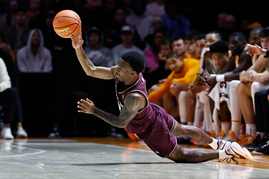 Texas A&M guard Jacari Lane (5) passes the ball as he falls to the floor during the first half of an NCAA college basketball game against Tennessee, Tuesday, Jan. 13, 2026, in Knoxville, Tenn. (AP Photo/Wade Payne)
