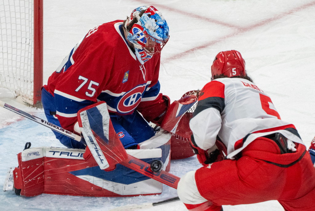Montreal Canadiens goaltender Jakub Dobes (75) stops a shot by Carolina Hurricanes' Jalen Chatfield (5) during the second period of an NHL hockey game in Montreal, Tuesday, March 24, 2026. (Christinne Muschi/The Canadian Press via AP)