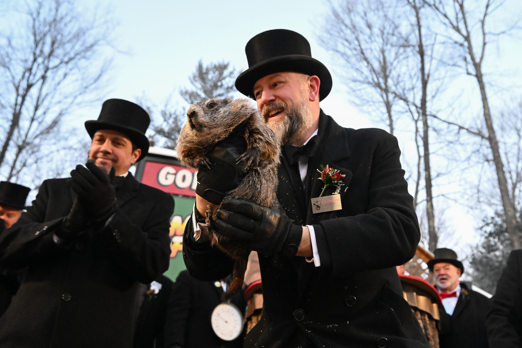 Groundhog Club handler A.J. Dereume holds Punxsutawney Phil, the weather prognosticating groundhog, during the 140th celebration of Groundhog Day on Gobbler's Knob in Punxsutawney, Pa., Monday, Feb. 2, 2026. Phil's handlers said that the groundhog has forecast six more weeks of winter. (AP Photo/Barry Reeger)