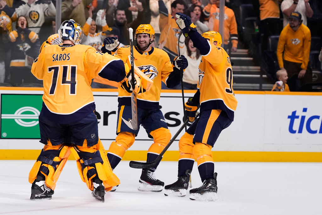 Nashville Predators goaltender Juuse Saros (74) is congratulated by left wing Cole Smith (36) and center Ryan O'Reilly, right, after the team's win against the New York Islanders in a shootout of an NHL hockey game Thursday, Jan. 8, 2026, in Nashville, Tenn. (AP Photo/George Walker IV)