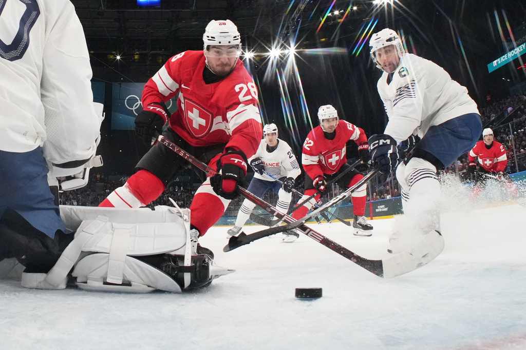 Switzerland's Timo Meier, center, scores his sides third goal past France's goalkeeper Antoine Keller during a preliminary round match of men's ice hockey between Switzerland and France at the 2026 Winter Olympics, in Milan, Italy, Thursday, Feb. 12, 2026. (Mike Segar/Pool Photo via AP)