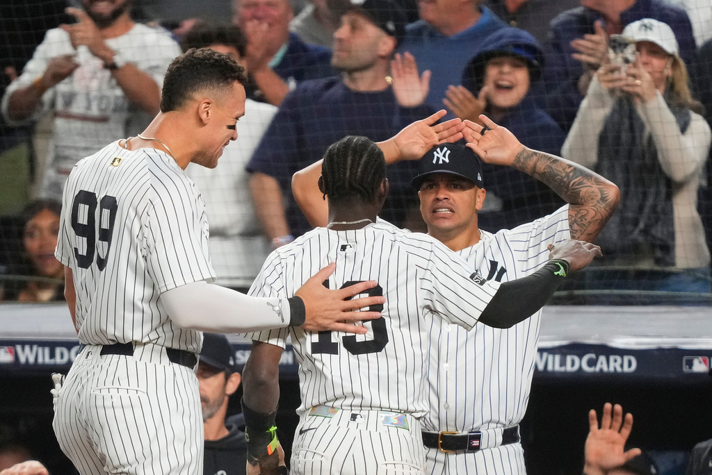 New York Yankees Jazz Chisholm Jr. (13) is congratulated by teammates after scoring the go-ahead run against the Boston Red Sox during the eighth inning of Game 2 of an American League wild-card baseball playoff series, Wednesday, Oct. 1, 2025, in New York. (AP Photo/Yuki Iwamura)