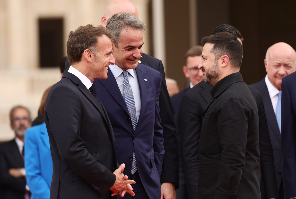 French President Emmanuel Macron, left, Ukrainian President Volodymyr Zelenskyy, centre right, and Greek Prime Minister Kyriakos Mitsotakis talk during the Coalition of the Willing summit on security guarantees for Ukraine, at the Hotel des Invalides in Paris, Monday, July 2026. (Teresa Suares/Pool Photo via AP)