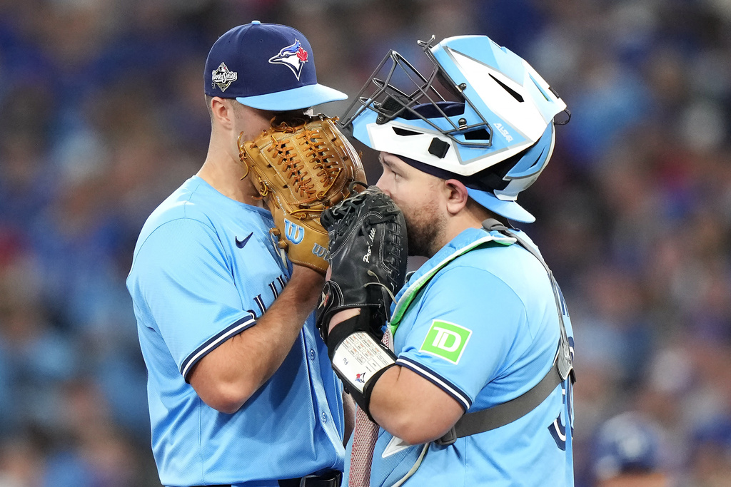 Toronto Blue Jays pitcher Mason Fluharty, left, and catcher Alejandro Kirk talk on the mound before a pitching change against the Los Angeles Dodgers during the eighth inning in Game 6 of baseball's World Series in Toronto on Friday, Oct. 31, 2025. (Nathan Denette/The Canadian Press via AP)