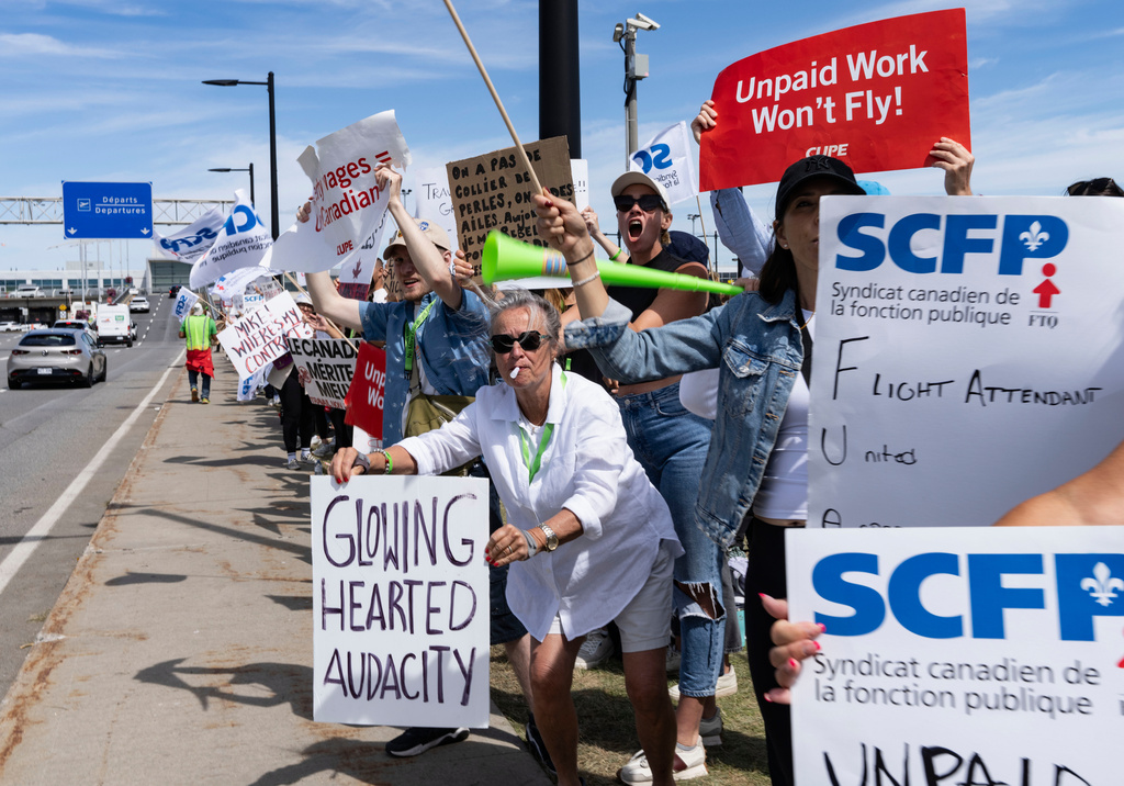 Air Canada flight attendants and supporters picket outside Montreal-Pierre Elliott Trudeau International Airport in Dorval, Quebec, Monday, Aug. 18, 2025. (Christinne Muschi/The Canadian Press via AP)