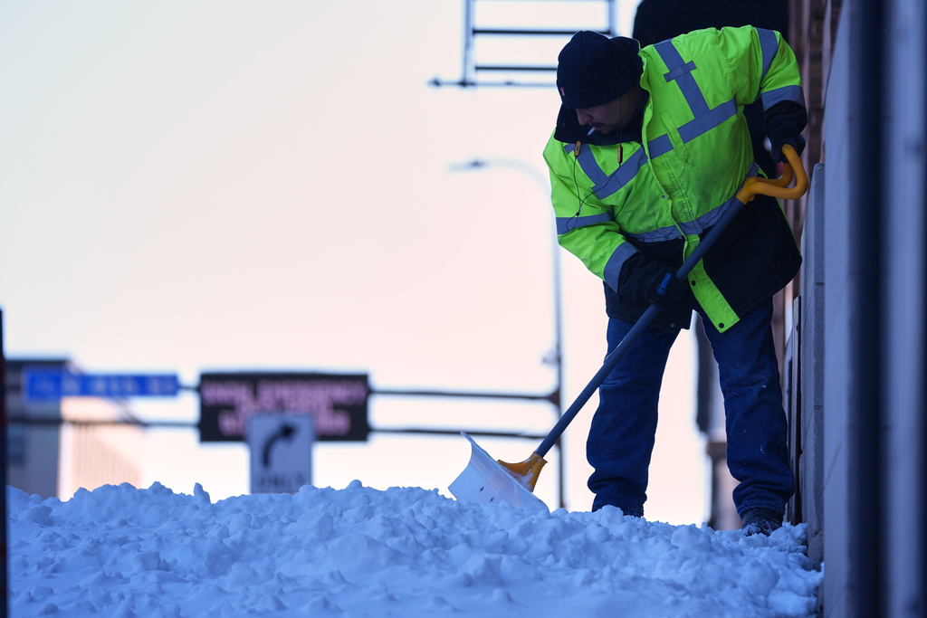 A man shovels snow after a snowstorm Monday, March 16, 2026, in Minneapolis. (AP Photo/Abbie Parr)