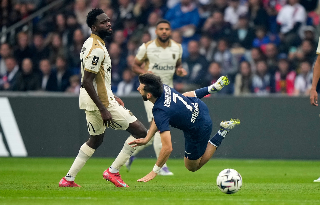 PSG's Khvicha Kvaratskhelia, right, is fouled by Len's Florian Sage during the French League One soccer match between Paris Saint-Germain and Le Havre at the Parc des Princes stadium in Paris, Sunday, Sept. 14, 2025. (AP Photo/Michel Euler)