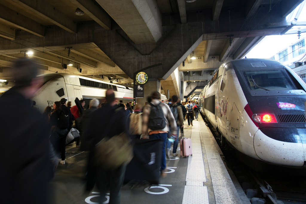 People board a high-speed train at the Montparnasse train station after a man wielding a knife at the station was shot and wounded by police, Friday, Nov. 14, 2025 in Paris. (AP Photo/Christophe Ena)