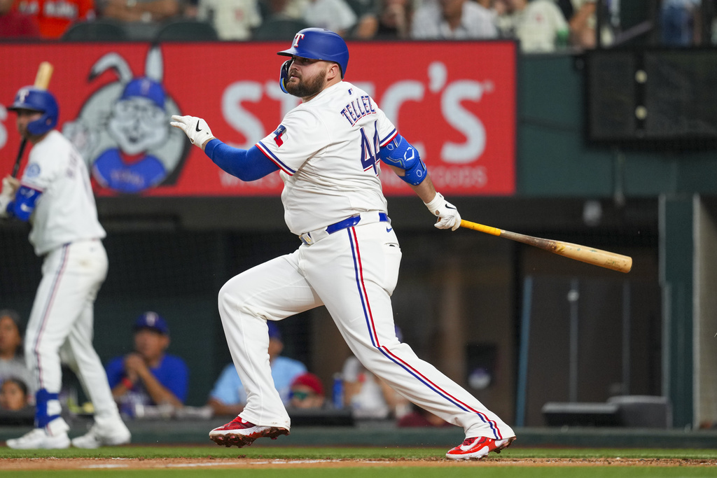 Texas Rangers' Rowdy Tellez watches his ball as he collects an RBI single to score Joc Pederson during the third inning of a baseball game against the Miami Marlins Saturday, Sept. 20, 2025, in Arlington, Texas. (AP Photo/Julio Cortez)