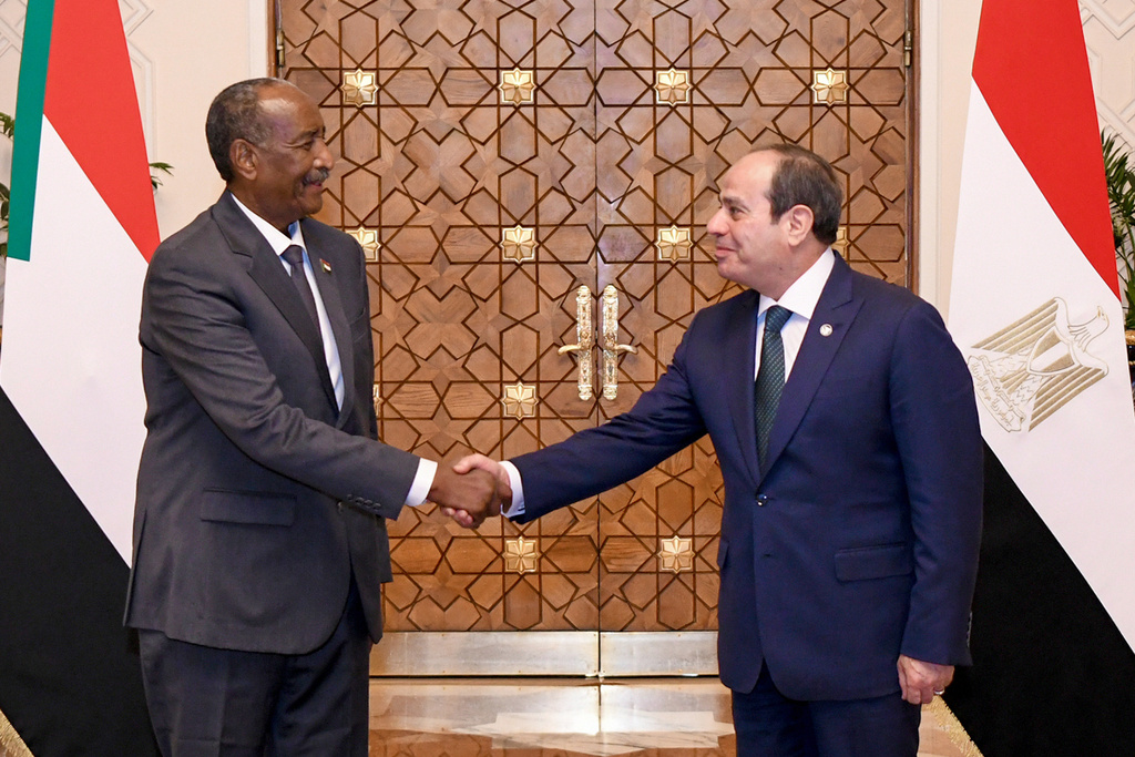 In this photo, provided by Egypt's presidency media office, Egyptian President Abdel-Fattah el-Sissi, greets Sudan's top general Gen. Abdel-Fattah Burhan, at the Presidential Palace in Cairo, Egypt, Thursday, Dec. 18, 2025. (Egyptian Presidency Media Office via AP)