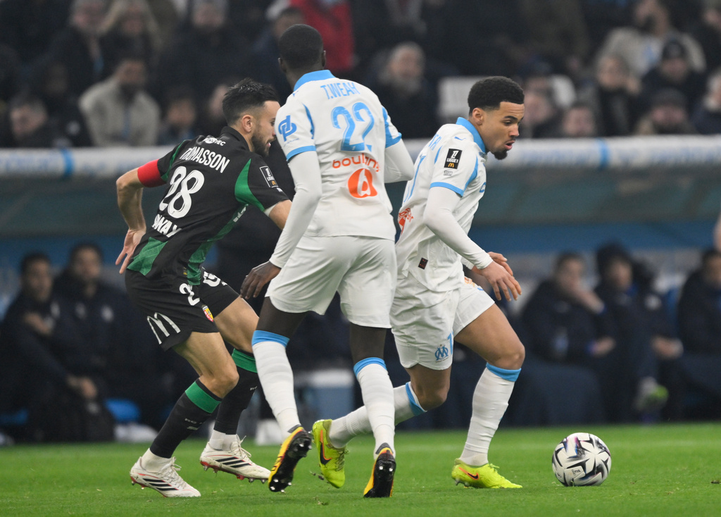 Lens' Adrien Thomasson, left, challenges for the ball with Marseille's Ethan Nwaneri during the French League One soccer match between Marseille and Lens in Marseille, France, Saturday, Jan. 24, 2026. (AP Photo/Philippe Magoni)