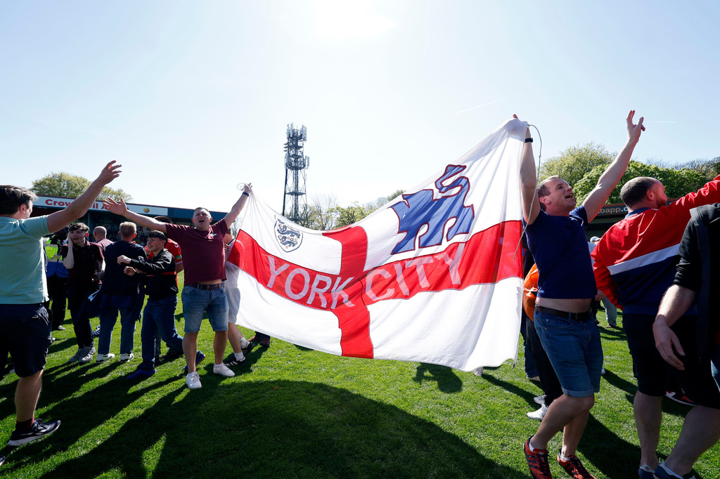 York City fans celebrate on the pitch at the final whistle after the National League match between Rochdale and York City in Rochdale, England, Saturday April 25, 2026. (Cody Froggatt/PA via AP)