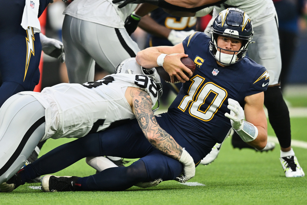 Las Vegas Raiders defensive end Maxx Crosby (98) sacks Los Angeles Chargers quarterback Justin Herbert (10) during the second half of an NFL football game, Sunday, Nov. 30, 2025, in Inglewood, Calif. (AP Photo/William Liang)