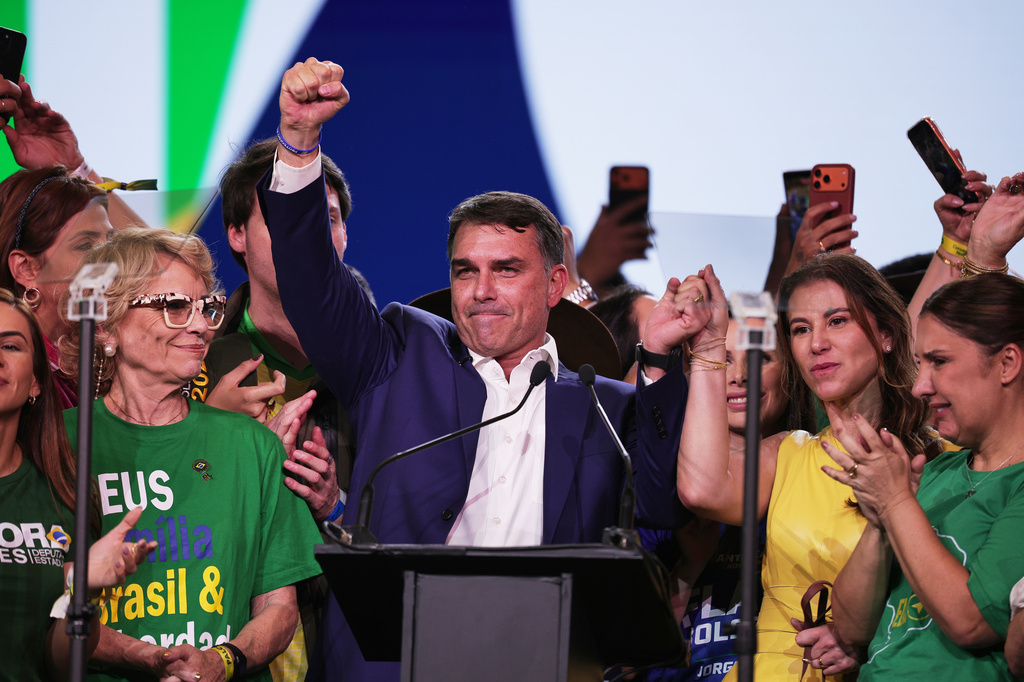 Brazilian Sen. Flavio Bolsonaro, center, and his wife Fernanda raise their arms in unison during the Liberal Party convention where Bolsonaro was confirmed as the party's presidential candidate, in Sao Paulo, Saturday, July 25, 2026. (AP Photo/Ettore Chiereguini)