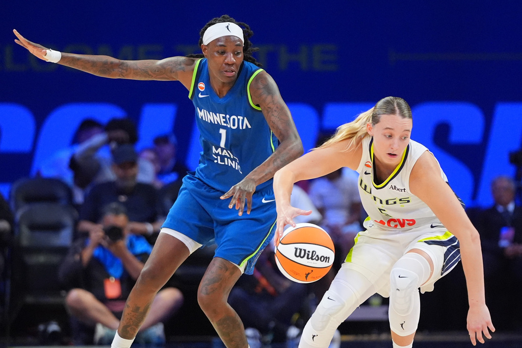 Dallas Wings guard Paige Bueckers, right, is defended by Minnesota Lynx forward Natasha Howard (1) during the second half of a WNBA basketball game in Arlington, Texas, Thursday, May 14, 2026. (AP Photo/LM Otero)