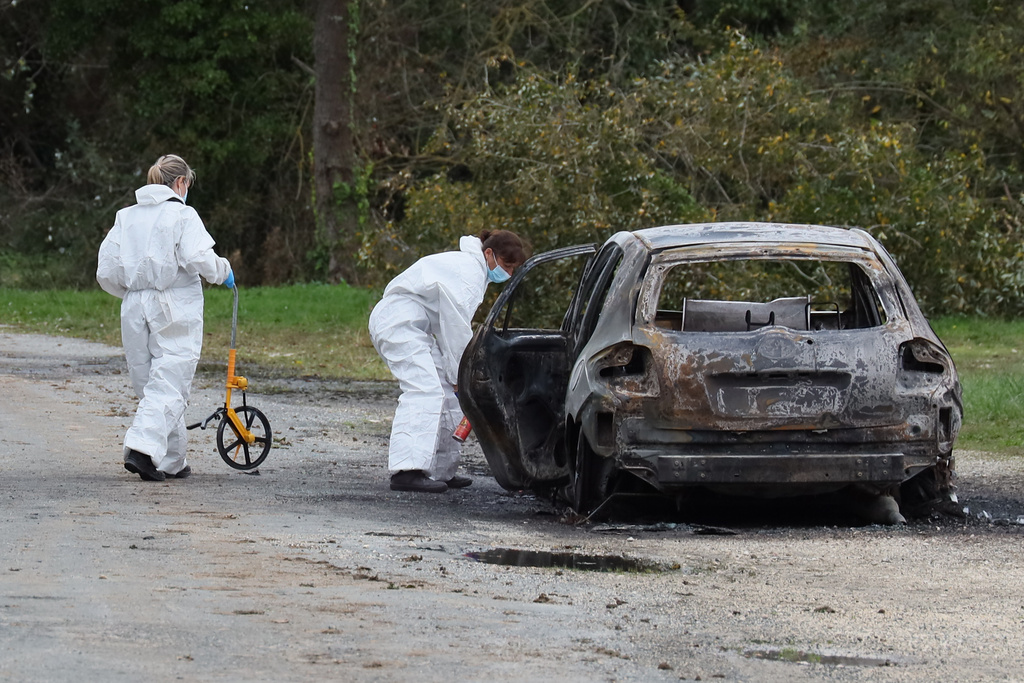 Investigators work by the burned car after a motorist deliberately rammed pedestrians and cyclists across two neighbouring towns on the Ile d'Oleron, off the Atlantic coast, injuring people before being detained by gendarmes, Wednesday, Nov. 5, 2025 in Saint-Pierre-d'Oleron. (AP Photo/Yohan Bonnet)