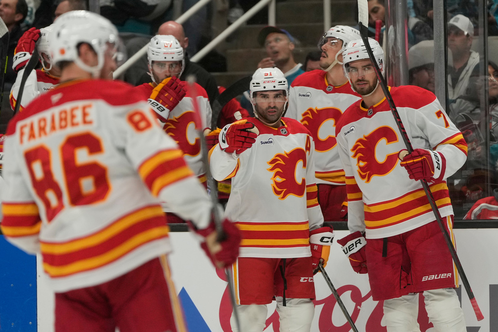 Calgary Flames center Nazem Kadri, middle, is congratulated by teammates after scoring against the San Jose Sharks during the second period of an NHL hockey game in San Jose, Calif., Thursday, Feb. 26, 2026. (AP Photo/Jeff Chiu)