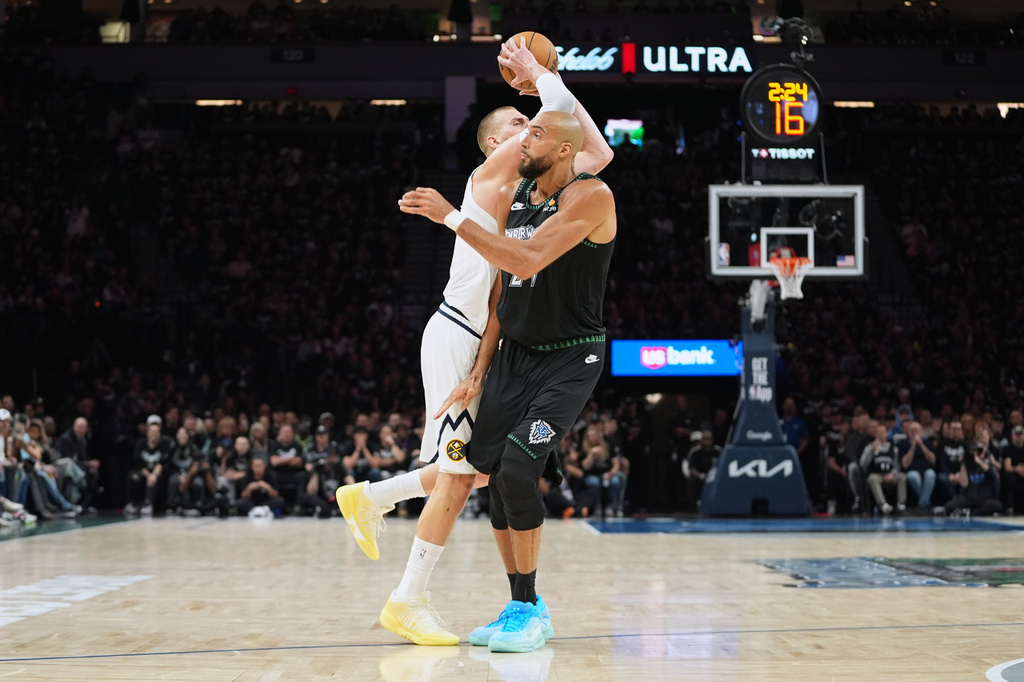 Denver Nuggets center Nikola Jokic (15), back, is fouled by Minnesota Timberwolves center Rudy Gobert (27) during the first half in Game 3 of a first-round NBA basketball playoff series, Thursday, April 23, 2026, in Minneapolis. (AP Photo/Abbie Parr)