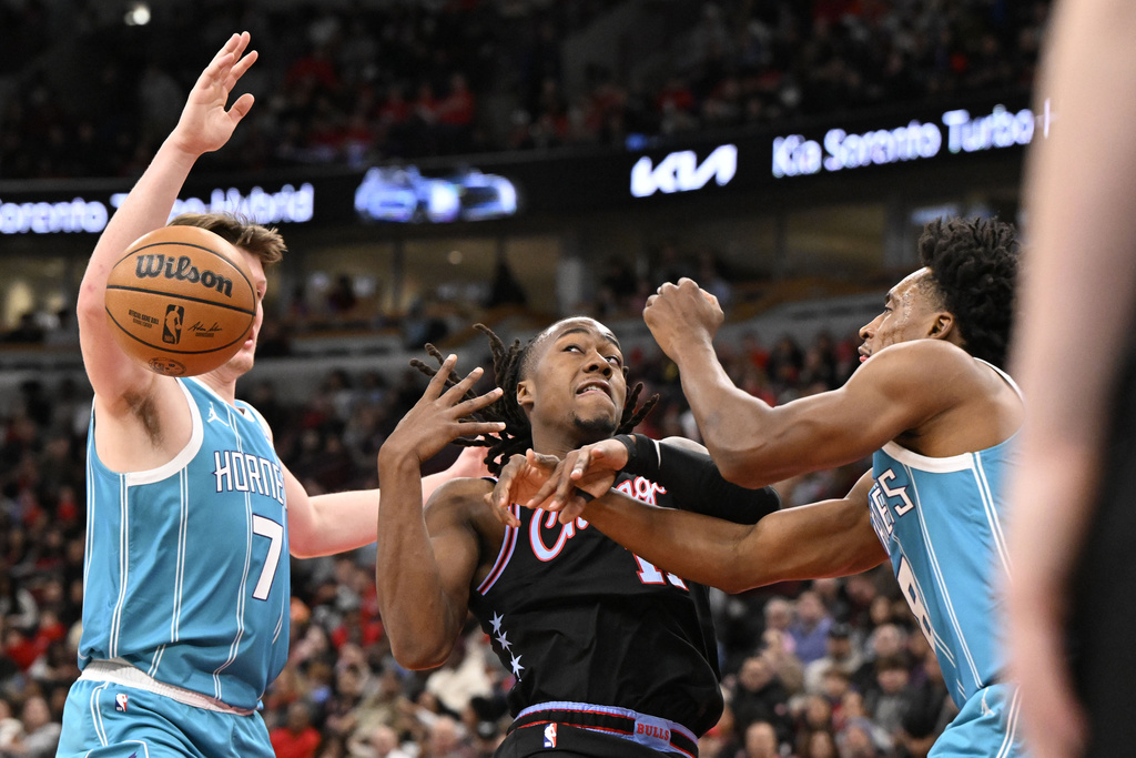 Chicago Bulls guard Ayo Dosunmu, center, loses the ball to Charlotte Hornets guard Kon Knueppel (7) and guard Collin Sexton during the first half of an NBA basketball game Saturday, Jan. 3, 2026, in Chicago. (AP Photo/Matt Marton)