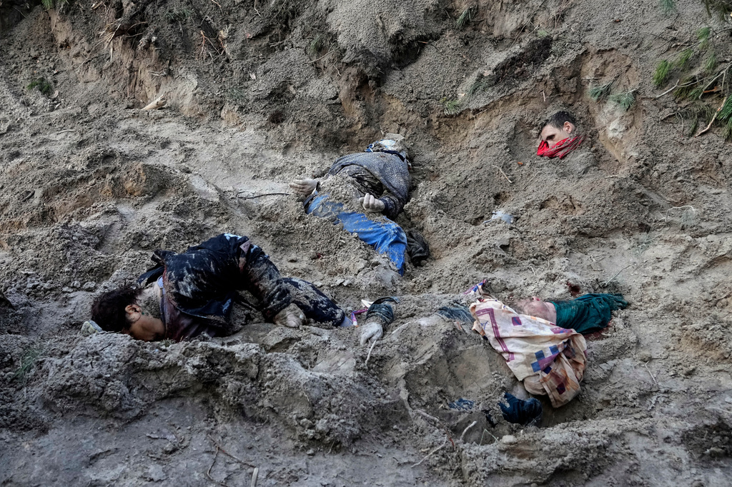 EDS NOTE: GRAPHIC CONTENT - FILE - The bodies of people lie half-buried in a mass grave in Motyzhyn close to Kyiv, Ukraine, Monday, April 4, 2022. (AP Photo/Efrem Lukatsky)