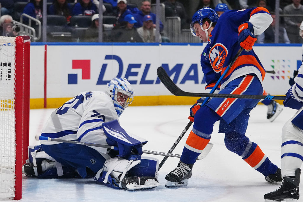 Toronto Maple Leafs goaltender Artur Akhtyamov, left, protects the net from New York Islanders' Calum Ritchie during the second period of an NHL hockey game Thursday, April 9, 2026, in Elmont, N.Y. (AP Photo/Frank Franklin II)