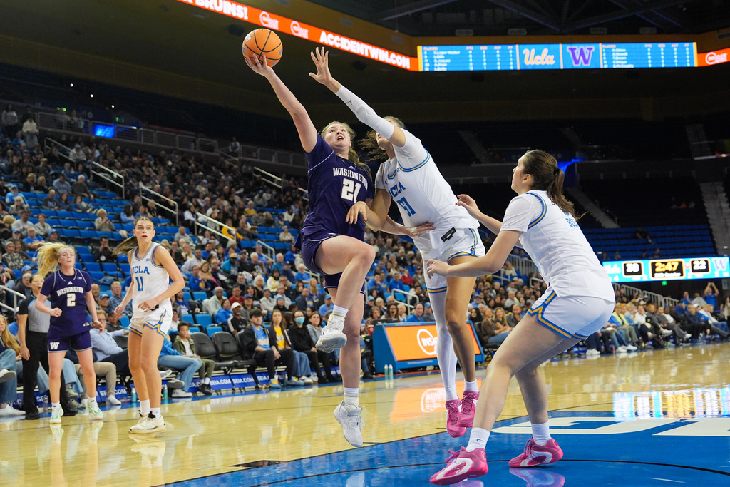 Washington forward Brynn McGaughy (21) drives to the basket under pressure by UCLA center Lauren Betts (51) during the first half of an NCAA women's college basketball game in Los Angeles, Thursday, Feb. 19, 2026. (AP Photo/Jae C. Hong)