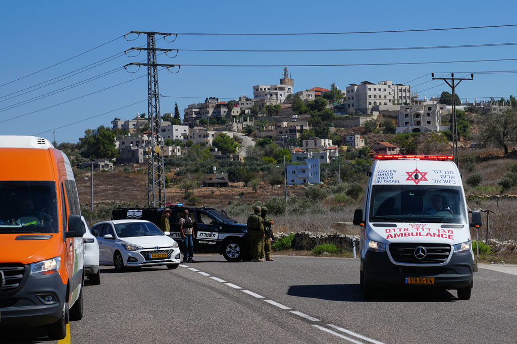 An ambulance moves on a road as Israeli police and soldiers stand guard near the site of a shooting attack that, according to Israeli officials, killed one Israeli near the settlement of Neve Tzuf, north of the West Bank city of Ramallah, Sunday, Sept. 20, 2026. (AP Photo/Mahmoud Illean)