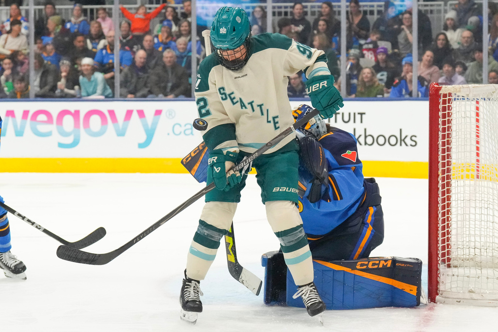 Seattle Torrent's Danielle Serdachny (92) tries to control the puck in front of Toronto Sceptres goaltender Raygan Kirk, right, during first-period PWHL hockey game action in Toronto, Sunday March 15, 2026. (Chris Young/The Canadian Press via AP)