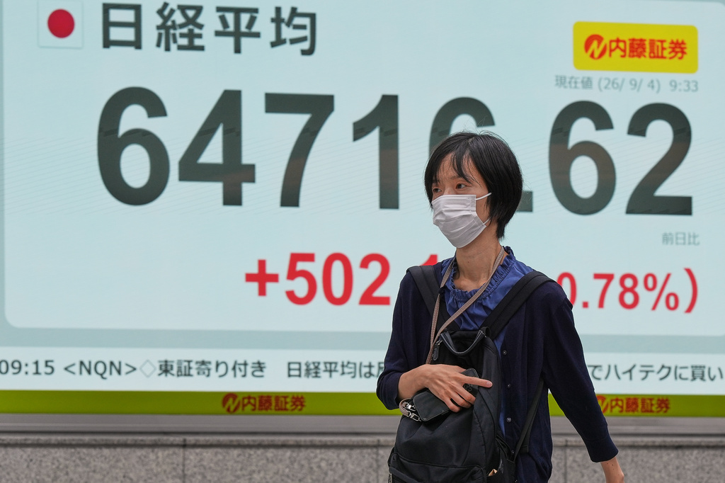 A person walks in front of an electronic stock board showing Japan's Nikkei index at a securities firm Friday, Sept. 4, 2026, in Tokyo. (AP Photo/Eugene Hoshiko)