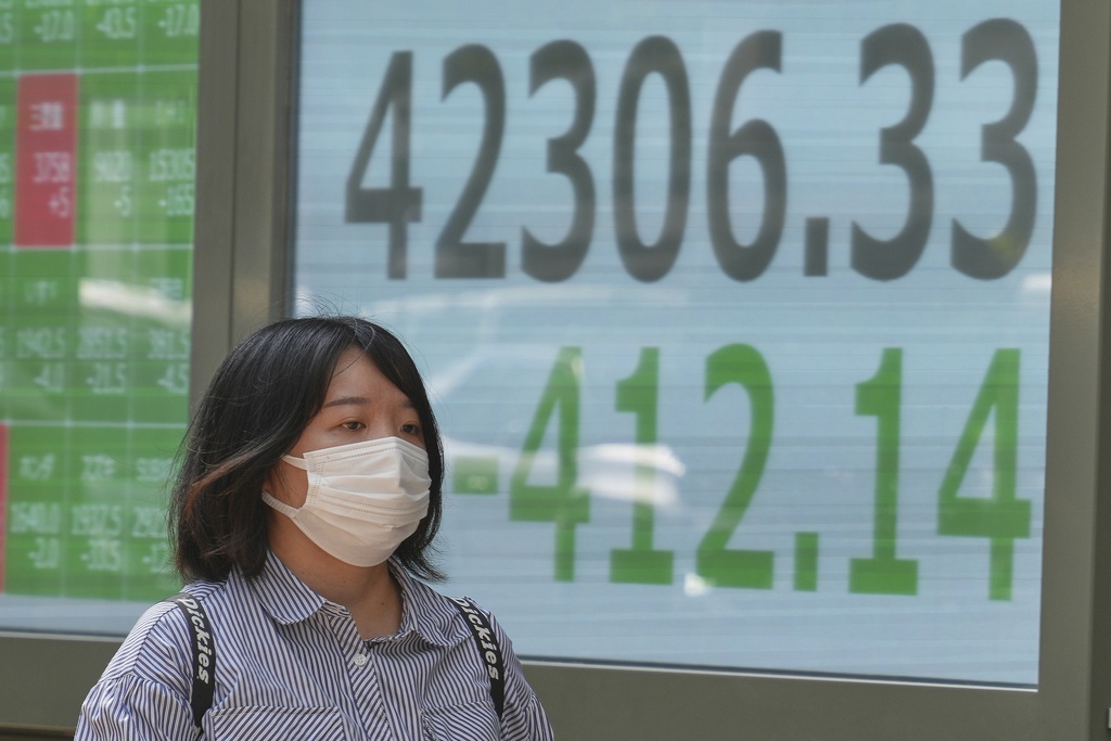 A person walks in front of an electronic stock board showing Japan's Nikkei index at a securities firm Monday, Sept. 1, 2025, in Tokyo. (AP Photo/Eugene Hoshiko)