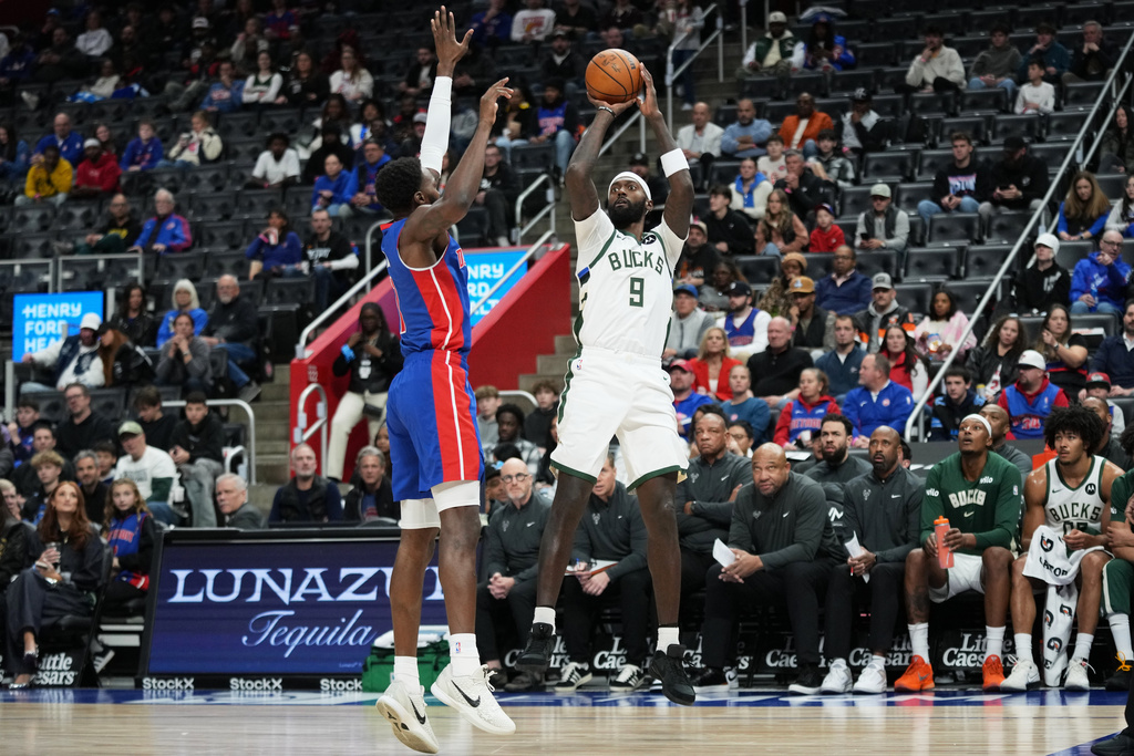 Milwaukee Bucks forward Bobby Portis, right, shoots against Detroit Pistons forward Paul Reed during the first half of an NBA basketball game, Saturday, Dec. 6, 2025, in Detroit. (AP Photo/Ryan Sun)