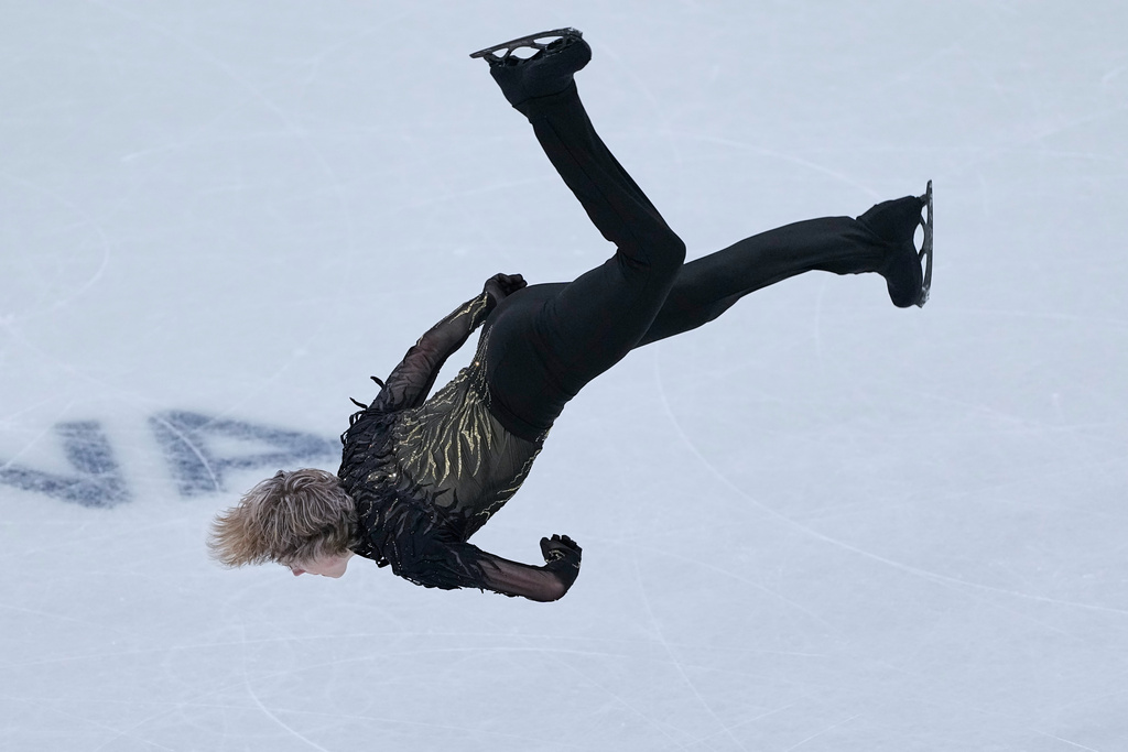 Ilia Malinin of the United States does a back flip while competing during the figure skating men's team event at the 2026 Winter Olympics, in Milan, Italy, Sunday, Feb. 8, 2026. (AP Photo/Natacha Pisarenko)
