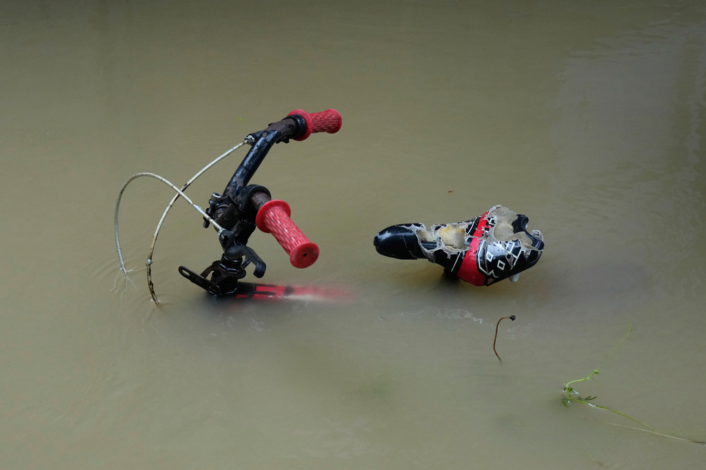 A bike is parked along floodwaters caused by heavy seasonal monsoon rains at Bagong Silangan village in Quezon city, Metro Manila, Philippines Monday, Aug. 10, 2026. (AP Photo/Aaron Favila) CORRECTION: Corrects typo in location to Silangan, instead of Silagan