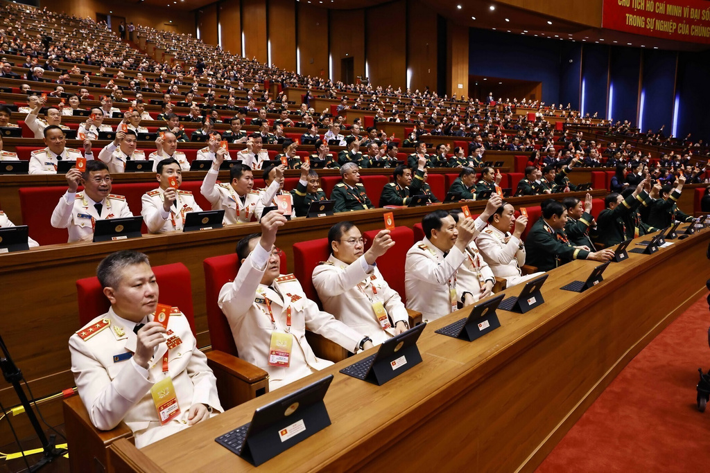 Delegates hold up Communist Party member cards as a vote during a meeting in preparation for the opening of the National Congress in Hanoi, Vietnam, Monday, Jan. 19, 2026. (Bui Cuong Quyet/VNA via AP)