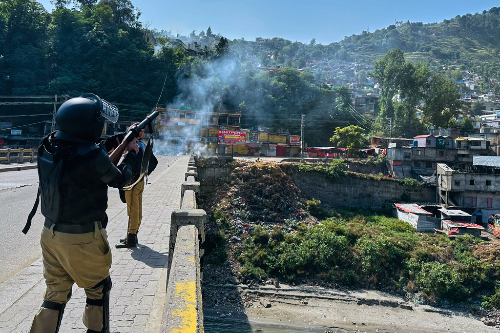CORRECTS HAME: Police officers fire tear gas shell to disperse members of the Awami Action Committee, a civil rights alliance holding a rally demanding subsidized food, electricity and other services, in Muzaffarabad, the capital of Pakistani controlled Kashmir, Tuesday, Sept. 30, 2025. (AP Photo/M.D. Mughal)