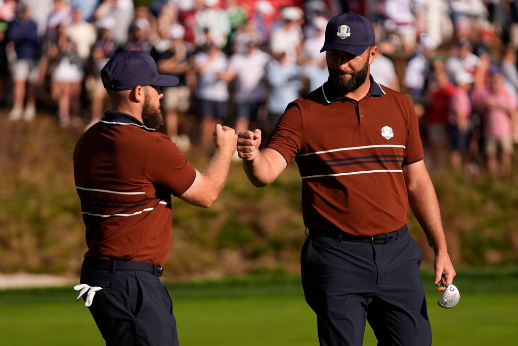 Europe's Tyrrell Hatton celebrates with Jon Rahm on the sixth hole at Bethpage Black golf course during the Ryder Cup golf tournament, Saturday, Sept. 27, 2025, in Farmingdale, N.Y. (AP Photo/Robert Bukaty)