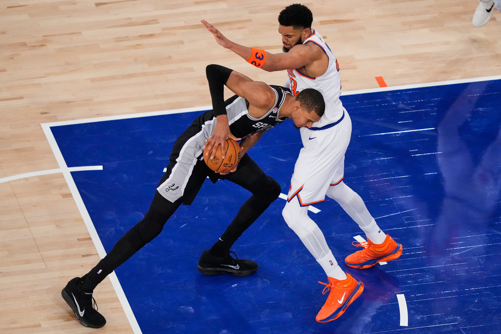 San Antonio Spurs forward Victor Wembanyama, left, tries to drive past New York Knicks center Karl-Anthony Towns during Game 3 of the NBA Finals basketball series, Monday, June 8, 2026, in New York. (AP Photo/Yuki Iwamura)