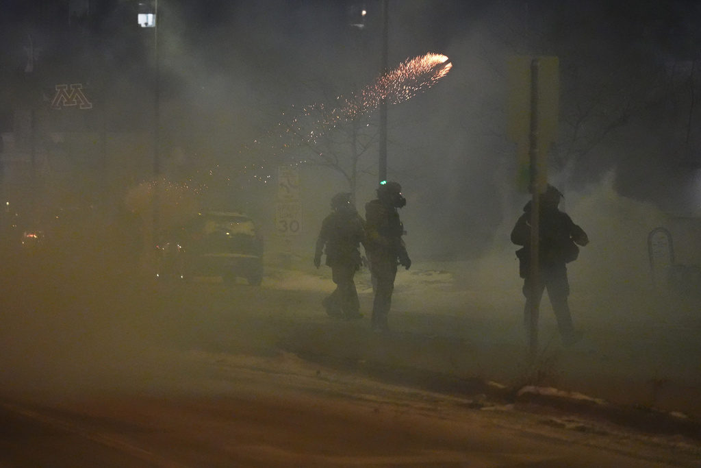 Flares are seen as federal agents try to clear the demonstrators near a hotel, using tear gas during a noise demonstration protest in response to federal immigration enforcement operations in the city Sunday, Jan. 25, 2026, in Minneapolis. (AP Photo/Adam Gray)