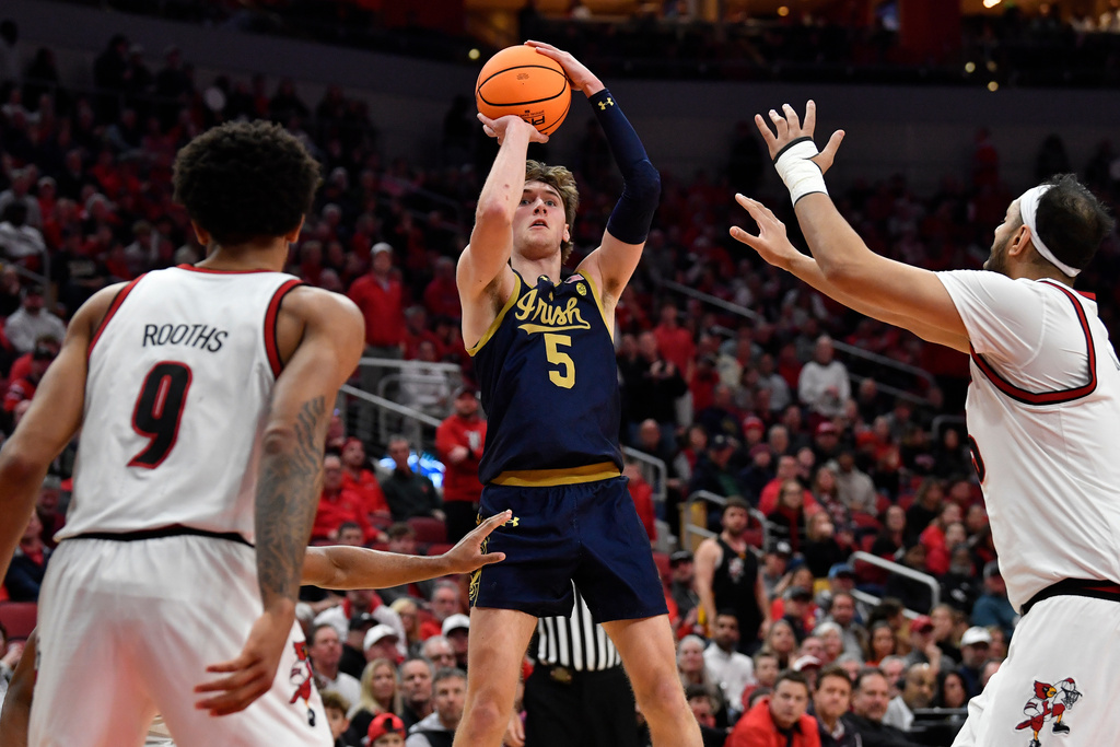 Notre Dame guard Cole Certa (5) shoots over Louisville forward Khani Rooths (9), and center Aly Khalifa (15) during the first half of an NCAA college basketball game in Louisville, Ky., Wednesday, Feb. 4, 2026. (AP Photo/Timothy D. Easley)