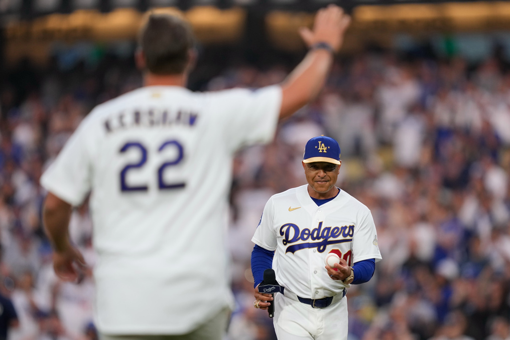 FILE - Former Los Angeles Dodgers pitcher Clayton Kershaw, left, waves as manager Dave Roberts waits before throwing out the ceremonial first pitch and receiving his ring during a World Series ring ceremony prior to a baseball game against the Arizona Diamondbacks, Friday, March 27, 2026, in Los Angeles. (AP Photo/Mark J. Terrill, File)