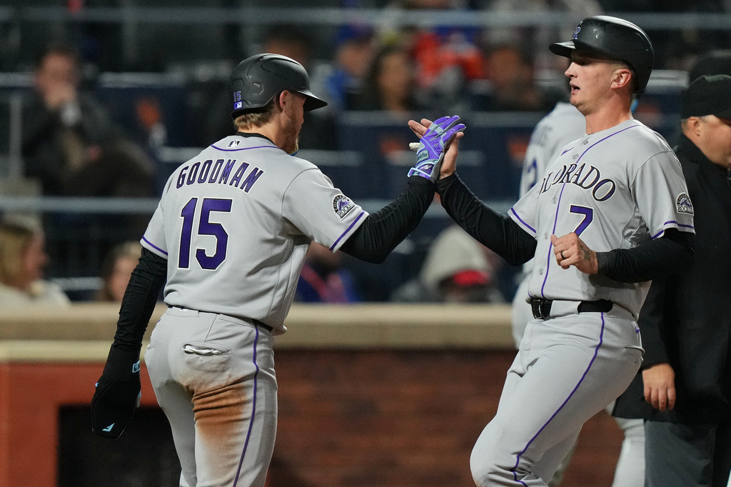 Colorado Rockies' TJ Rumfield (7) celebrates with Hunter Goodman (15) after they score on a single byu Troy Johnston during the seventh inning of a baseball game against the New York Mets Friday, April 24, 2026, in New York. (AP Photo/Frank Franklin II)