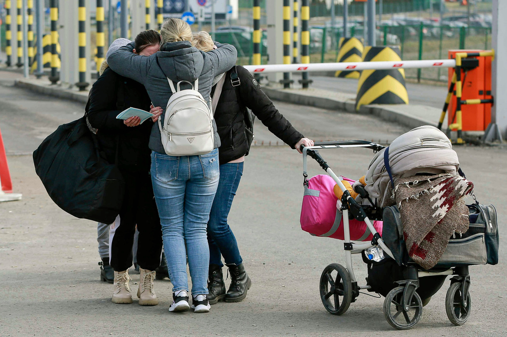 FILE - Family members hug as they reunite, after fleeing conflict in Ukraine, at the Medyka border crossing, in Poland, Sunday, Feb. 27, 2022. (AP Photo/Visar Kryeziu, File)