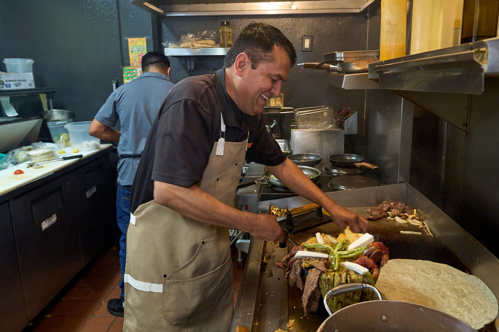 Mexican restaurant owner-chef Marco Mendoza prepares a hot molcajete, a traditional Mexican dish, at Cuernavaca's Grill in downtown Los Angeles, Tuesday, April 28, 2026. (AP Photo/Damian Dovarganes)