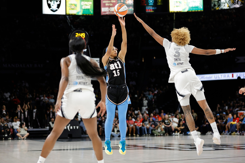Atlanta Dream guard Allisha Gray (15) shoots between Las Vegas Aces guard Jackie Young (0) and forward NaLyssa Smith (3) during the first half of a WNBA basketball game Tuesday, Aug. 18, 2026, in Las Vegas. (Steve Marcus/Las Vegas Sun via AP)
