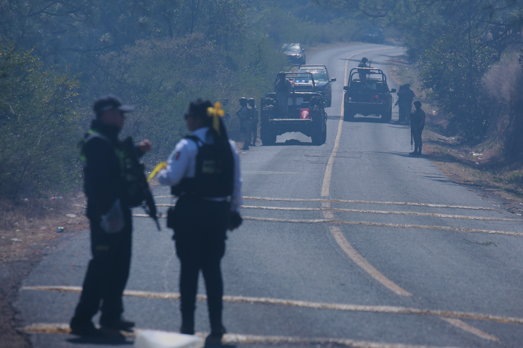 Soldiers stand guard in Cointzio, Michoacán state, Mexico, Sunday, Feb. 22, 2026, after the death of the leader of the Jalisco New Generation Cartel, Nemesio Rubén Oseguera Cervantes, known as "El Mencho." (AP Photo/Armando Solis)