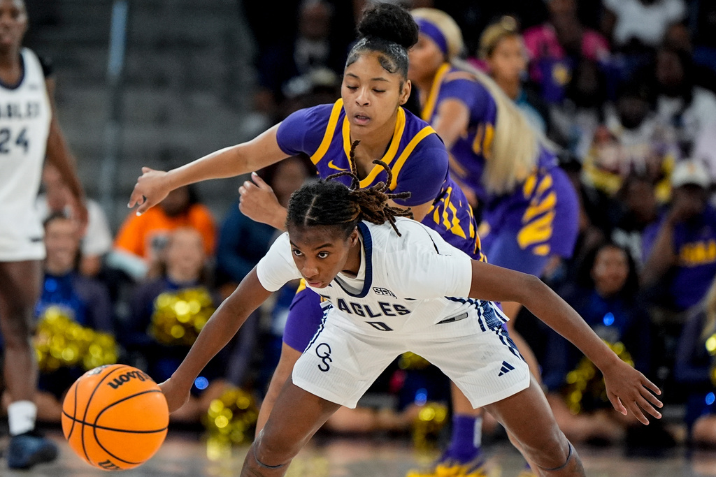 Georgia Southern guard Destiny Garrett (0) and Louisiana State guard Jada Richard (30) vie for a loose ball during the first half of an NCAA women's basketball game, Sunday, Nov. 9, 2025, in Statesboro. (AP Photo/Mike Stewart)