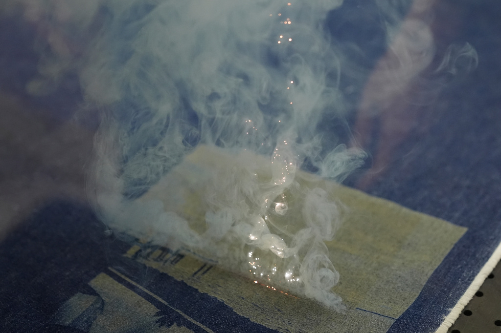 A laser is used to create a pattern and distress denim at the BPD Washhouse, a denim processing facility, in Jersey City, N.J., Tuesday, May 5, 2026. (AP Photo/Seth Wenig)
