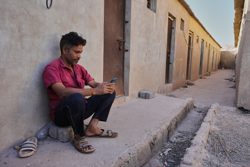 A migrant worker sits at a deserted ceramic workers' quarters in Morbi, in the Indian state of Gujarat, Wednesday, April 8, 2026. (AP Photo/Ajit Solanki)