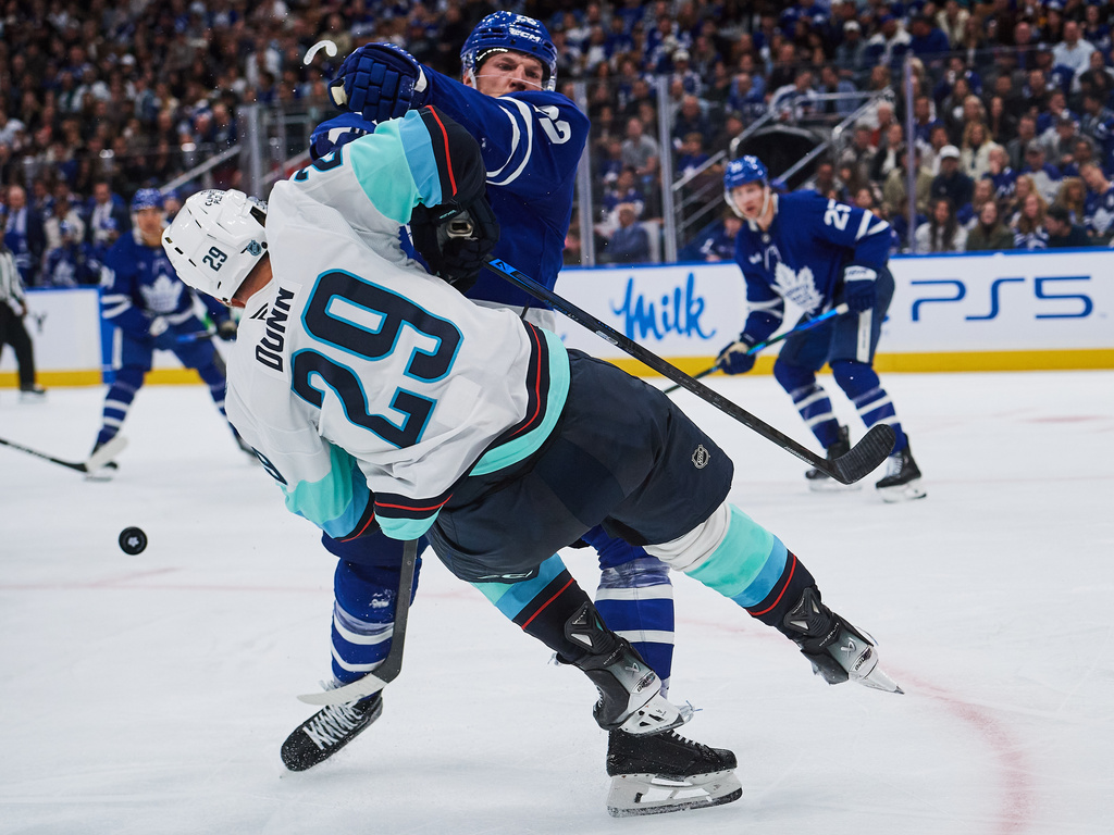Toronto Maple Leafs' Jake McCabe (22) checks Seattle Kraken's Vince Dunn (29) during third period NHL hockey action in Toronto, on Saturday, Oct. 18, 2025. (Sammy Kogan/The Canadian Press via AP)